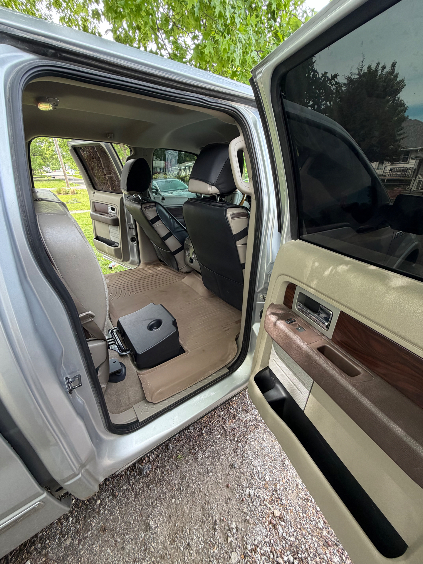 Ford F-150 rear cab interior with door open, leather seats and floor liners