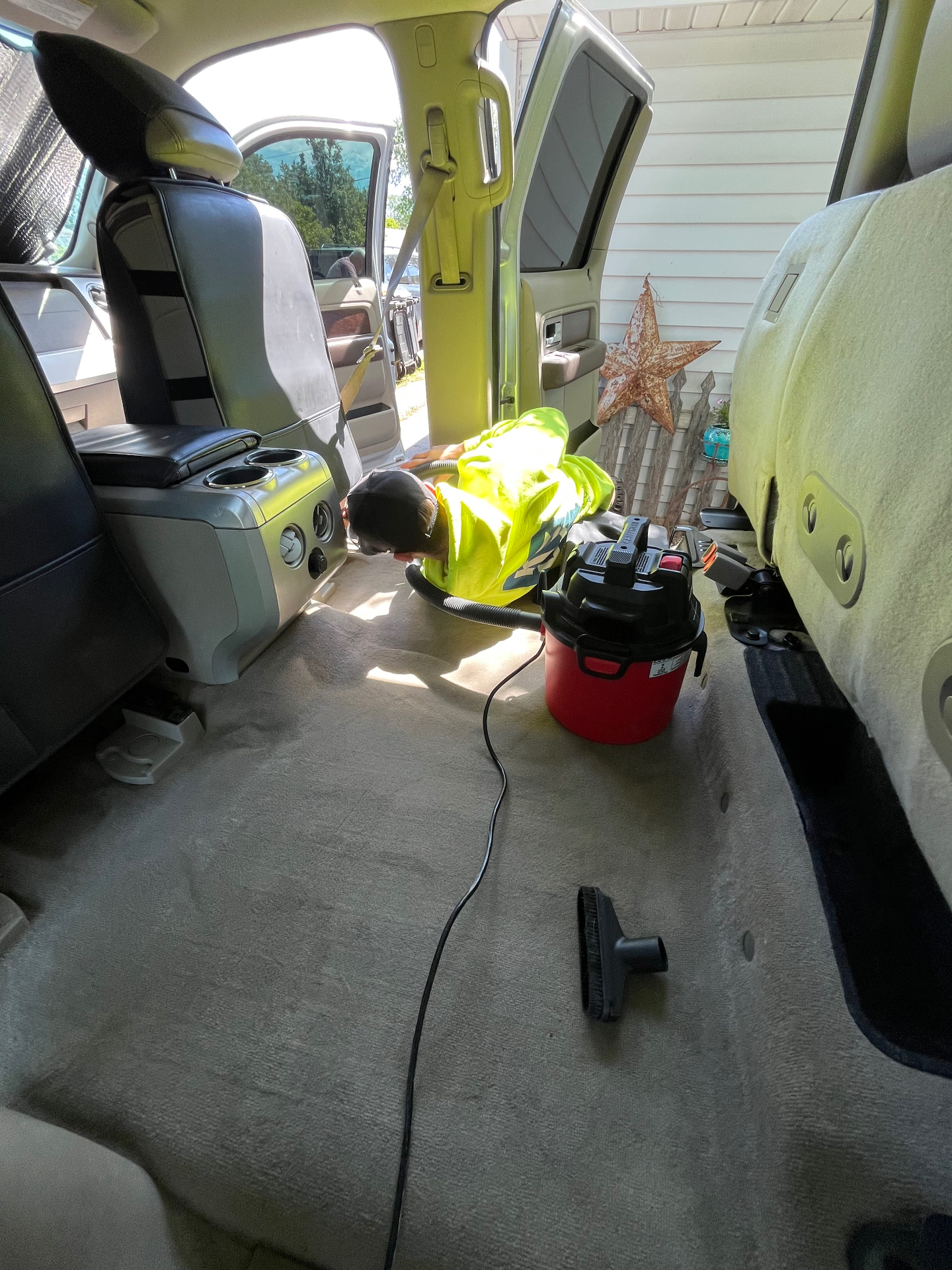 Vacuuming and steam-cleaning carpet in an SUV